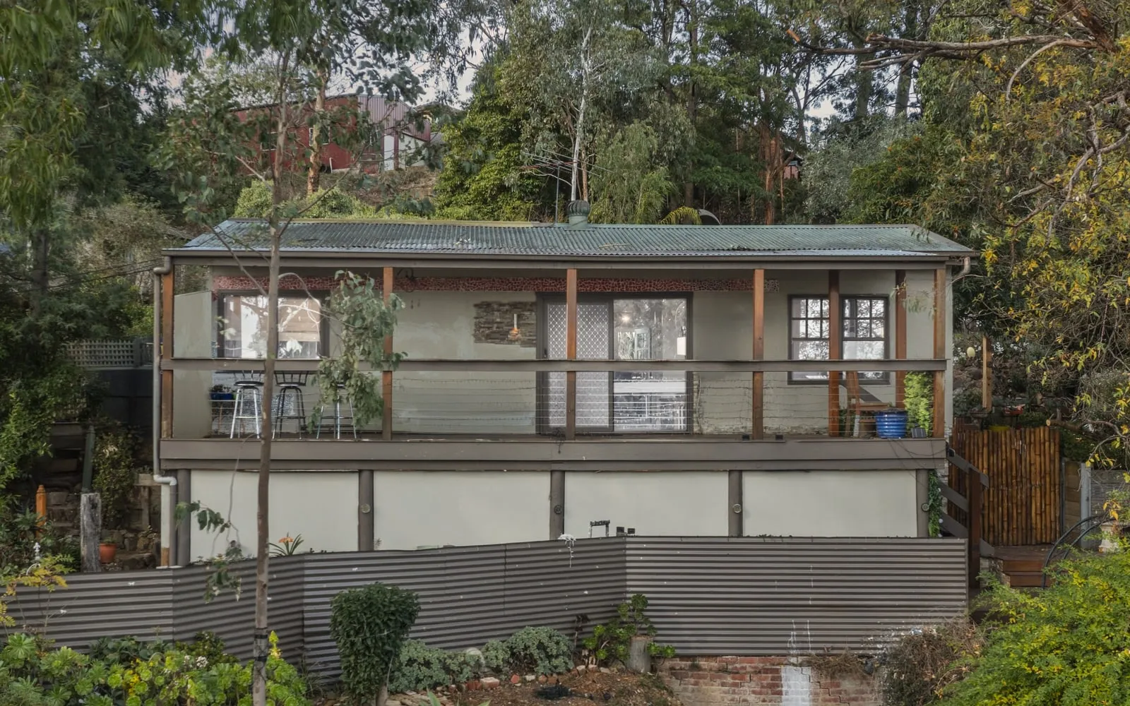 The front of a timber house among trees, from a listing shoot