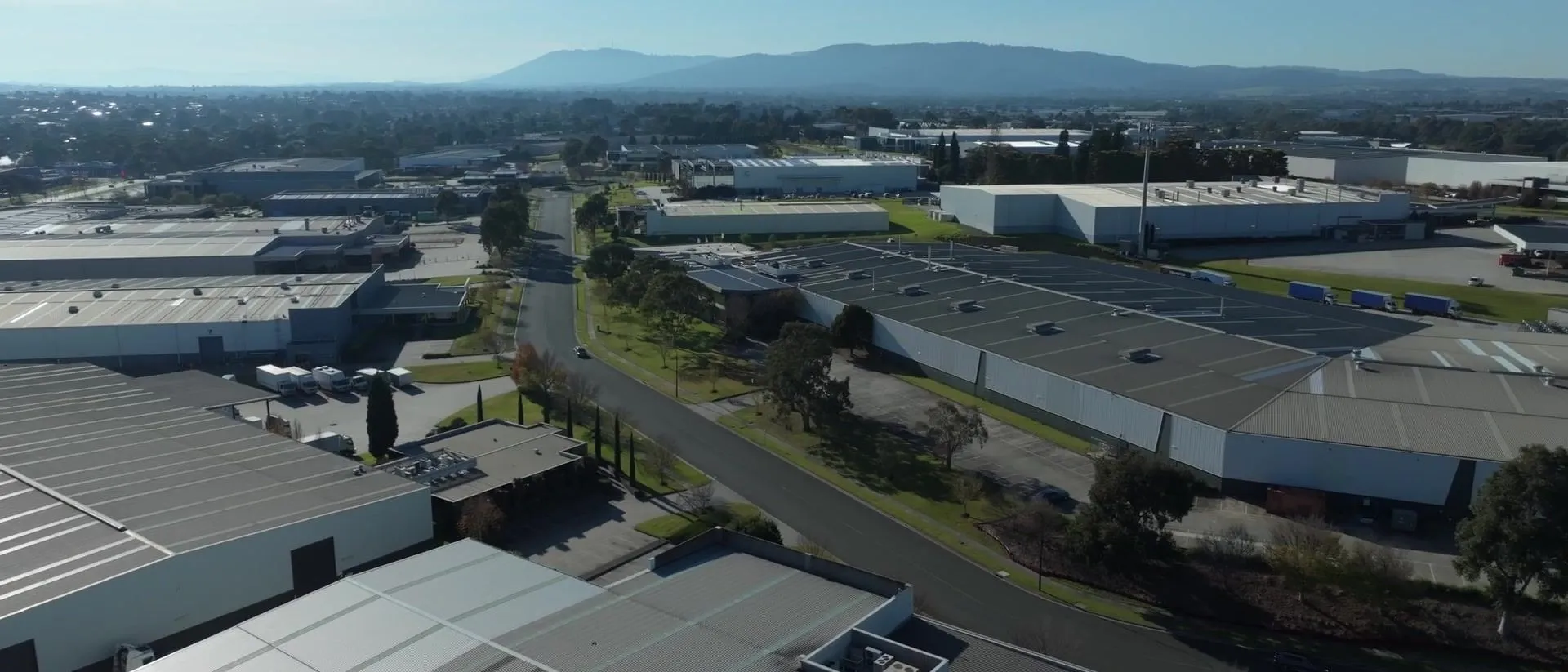 Aerial view over an industrial estate in Melbourne’s south-east, the Dandenongs behind